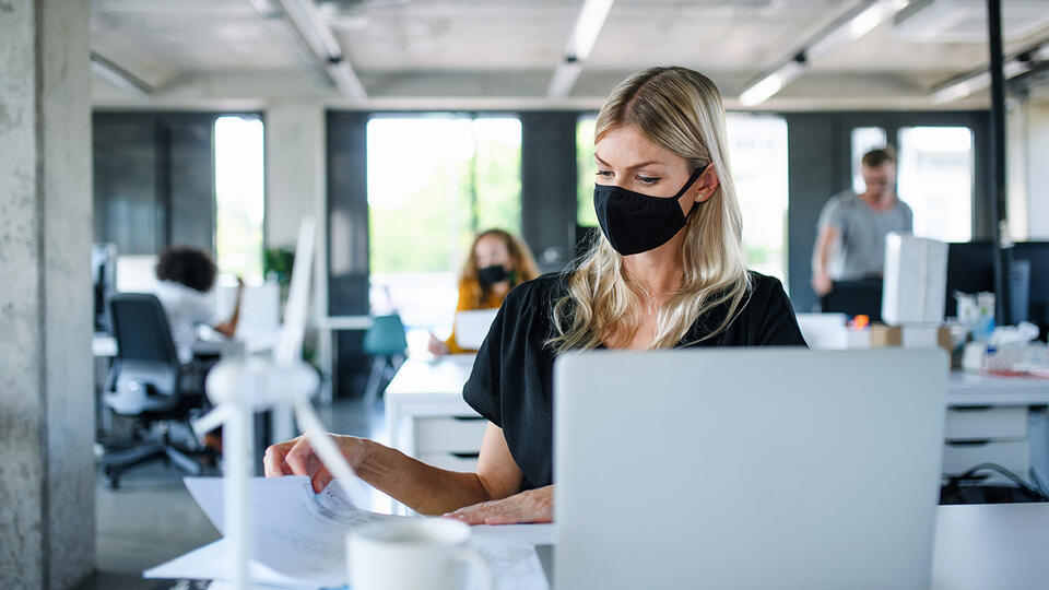 Woman at office desk with face mask